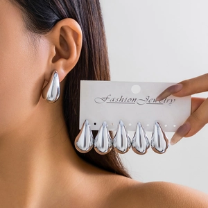 Detailed view of silver teardrop earrings with a smooth mirror finish on display cards