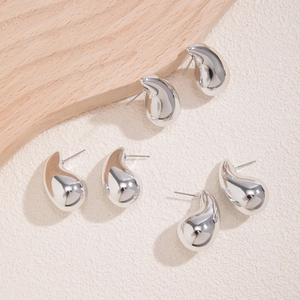 Macro shot of three pairs of silver teardrop earrings with high-polish mirror finish