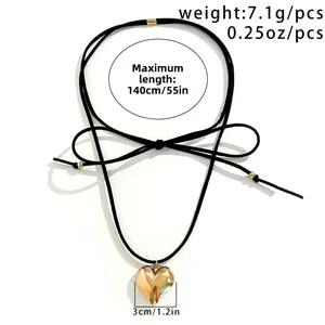 Detailed view of adjustable black cord choker with large 3cm polished gold heart pendant