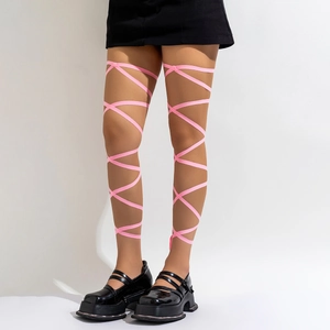 Roze elastische beenbanden met kruisontwerp gedragen met rok en platform schoenen