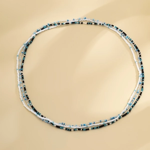 Macro shot van de meerlaagse tailleketting met kralen in blauw, wit en zwart