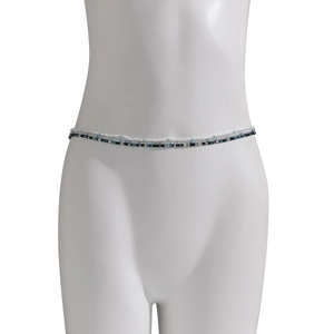 Gedetailleerde macro-opname van de driedelige handgemaakte blauw-witte elastische kralen buikketting