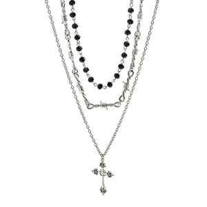 Dettaglio della collana gotica multistrato con croce d'argento e catena a spine