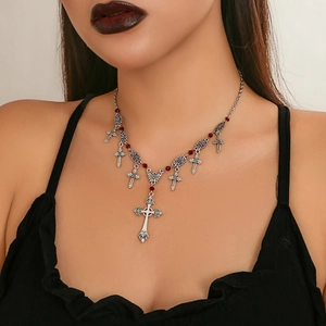 Close-up of gothic cross pendant necklace with red beads on silver metal chain