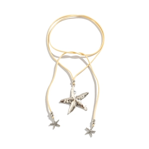 Macro detail of silver starfish pendant and beige suede cord bohemian ocean necklace
