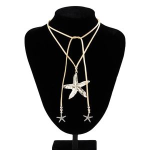 Detail of bohemian starfish pendant on beige suede cord with silver beads and sea accents