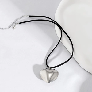 Detail of large polished silver heart pendant with black velvet cord and adjustable clasp