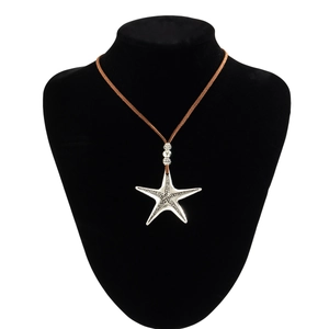 Detail of vintage silver starfish pendant with textured surface on brown cord