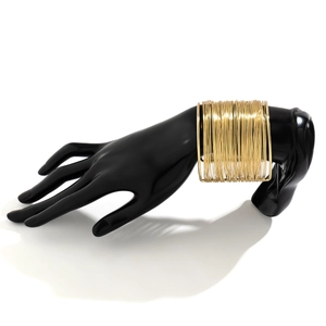 Macro shot of wide gold multi-layer wrap cuff bracelet on black hand display model