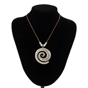 Macro view of a large vintage silver spiral pendant on a bohemian style necklace