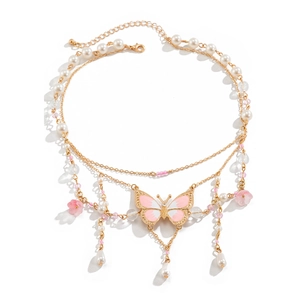 Detailansicht der goldenen y2k-Kette mit weißen Perlen, rosa Schmetterlingen und Blumen