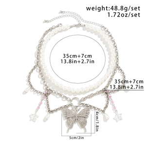 Details einer Y2K-Lagenhalskette mit großem Strass-Schmetterling und Perlenverzierung
