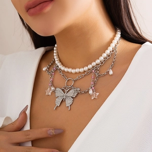 Nahaufnahme eines dreilagigen Y2K-Chokers mit silbernem Schmetterling und Perlen