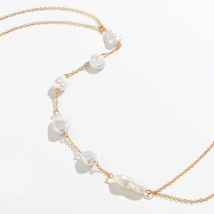 Detail of baroque pearl body chain with golden chain and irregular white pearls