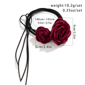 Detailed view of dark red fabric roses on a long black strap with size specifications