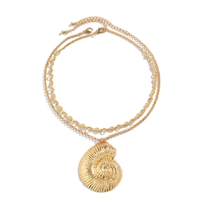 Detail of layered gold nautical necklace featuring a polished spiral conch shell pendant