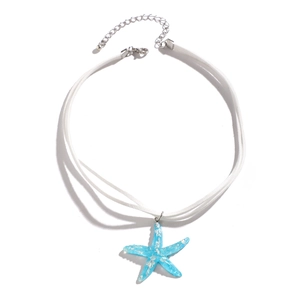Macro detail of blue resin starfish pendant with silver foil on white cord necklace