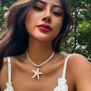 Detail of bohemian starfish pendant necklace worn by a model in a summer beach style