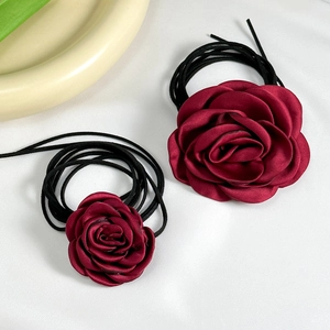 Retro satin rose choker and hair tie with dark red petals on elegant white background