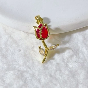 Detail view of a gold tulip pendant with red teardrop gem and marquise zirconia accents