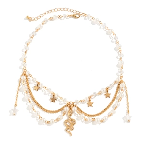 Details einer Perlenkette mit goldenen Sternen und einem Schlangenanhänger mit Kristallen