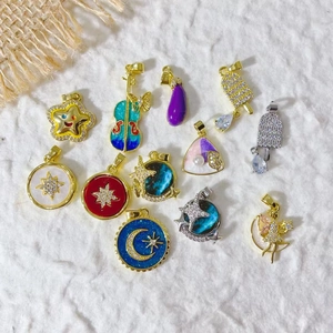 Detailed view of assorted gold-plated cherry, star and guitar pendants with enamel and cubic zirconia