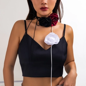 Detail of three fabric rose chokers in black, burgundy, and white with long wrap ribbons