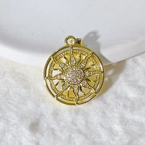 Golden sun pendant with cubic zirconia micro-inlay on white ceramic and plush background