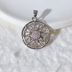 Polished silver sunflower pendant with micro-inset zircons on white plush background