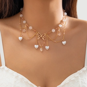 Nahaufnahme der mehrlagigen Gold-Choker-Halskette mit Perlen und Herzanhänger