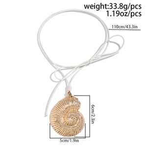 Macro view of gold spiral seashell pendant with white cord and size measurements