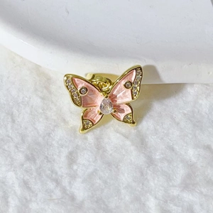 Detailed macro view of pink enamel butterfly pendant with cubic zirconia inlay on gold base