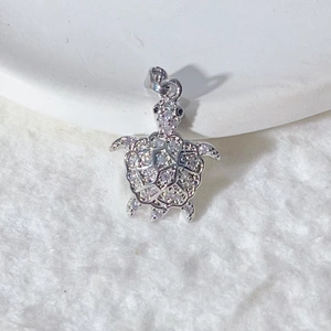 Silver turtle pendant with shimmering white cubic zirconia and detailed grid pattern shell
