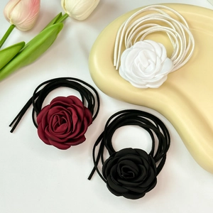 Close-up of handmade satin rose choker necklaces in cream, burgundy and black