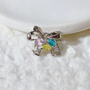 Sparkling silver puppy pendant with colorful zircon stones on white plush background