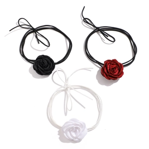 Three elegant fabric rose chokers in black, deep red, and white with slim tie ribbons