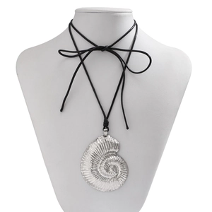 Close-up of silver nautilus shell pendant with spiral texture on black cord necklace