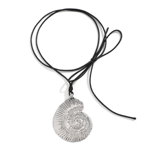 Macro shot of silver conch pendant with detailed texture on a black cord necklace
