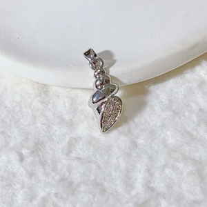 Macro detail of silver ocean conch pendant with white zircon stones on plush background