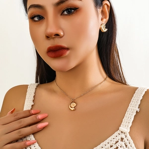 Detail of bohemian gold conch spiral jewelry set with necklace and stud earrings