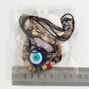 Detailansicht der blauen Evil Eye Kette mit Kristallanhänger und perlenbesetzter Wachskordel