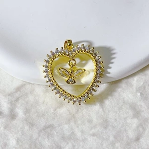 Macro shot of gold-plated heart pendant with micro-paved zircons and a flying bird detail