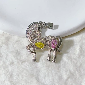 Macro shot of silver horse pendant with pavé cubic zirconia and colorful gemstones