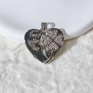 Macro shot of silver heart pendant with clover design and Happy Mother's Day engraving
