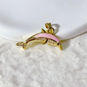 Dettaglio macro di un ciondolo a delfino placcato oro con smalto rosa e micro zirconi