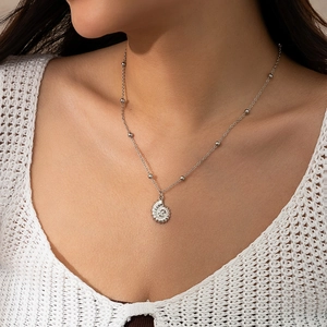 Detail of seashell pendant with sparkling zircons on a beaded silver chain necklace
