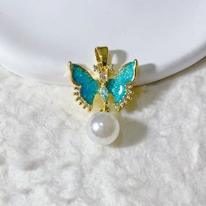 Macro-opname van vlinderhanger met blauwgroen emaille, zirkonia en een witte parel aan de onderkant