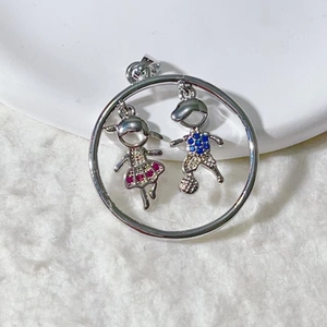 Detail of silver pendant with girl and boy figures inlaid with colorful zircon stones