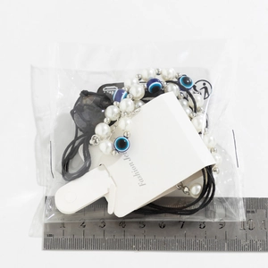 Detail von Evil Eye-Perlenketten und Armbändern mit Linealmaß und Verpackung