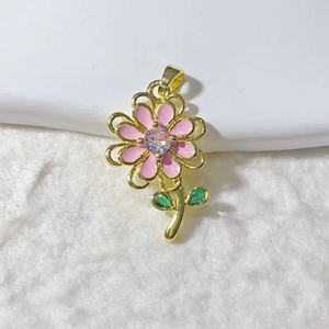 Ciondolo a fiore in smalto rosa con cornice dorata e gemme marquise verdi su sfondo bianco